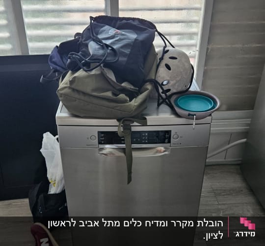 מדיח כלים עם תיק, קסדה ונעליים על הרצפה